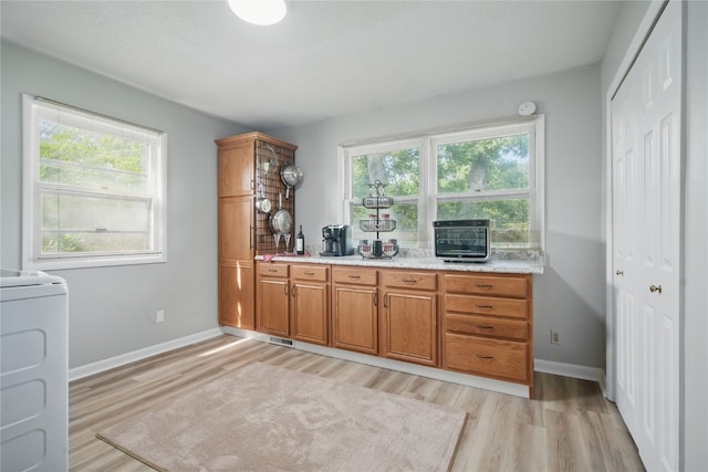 1649 Memorial Dr SE, Cedar Rapids, IA 52403 - kitchen with healthy amount of natural light, light wood-style floors, and brown cabinets