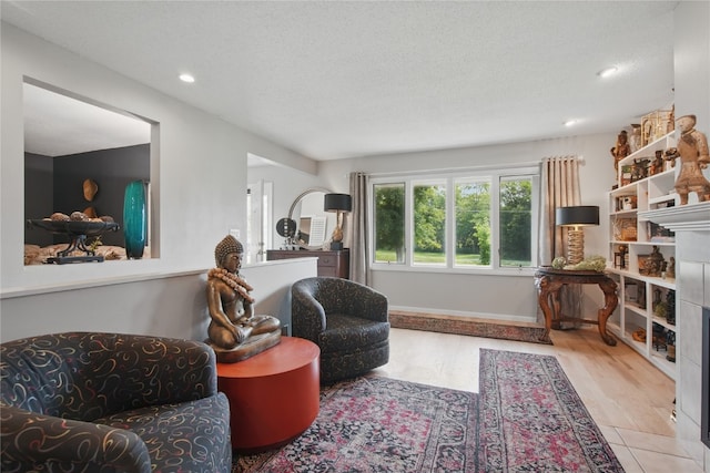 1649 Memorial Dr SE, Cedar Rapids, IA 52403 - living area with a tile fireplace, recessed lighting, wood finished floors, and a textured ceiling