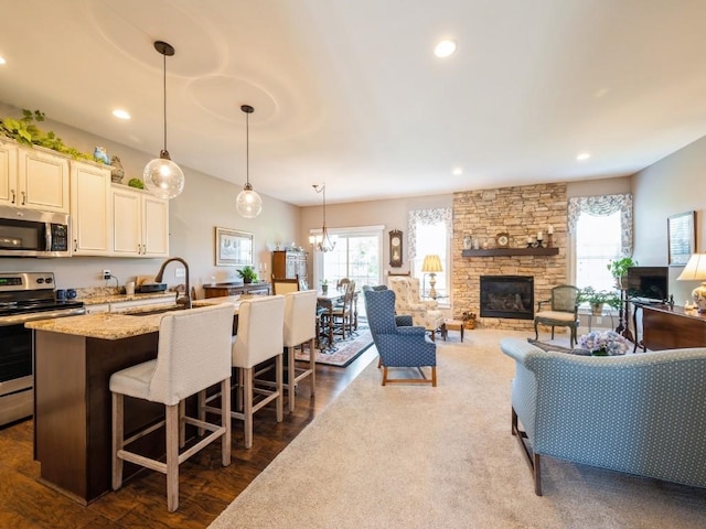 2940 Brookvalley Ct, Marion, IA 52302 - kitchen with appliances with stainless steel finishes, a sink, a fireplace, plenty of natural light, and recessed lighting