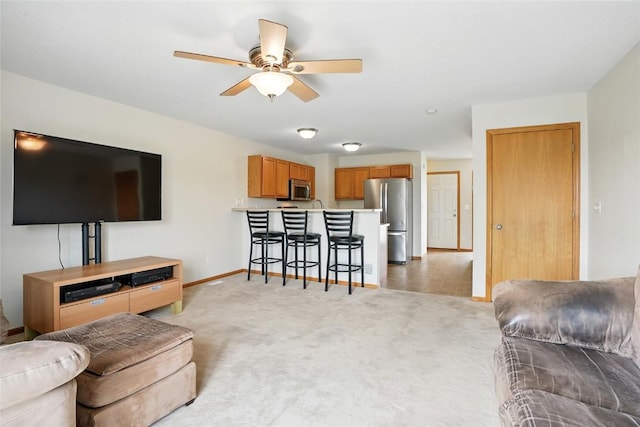 1450 Tower Ln NE, Cedar Rapids, IA 52402 - living area with light carpet, baseboards, and ceiling fan