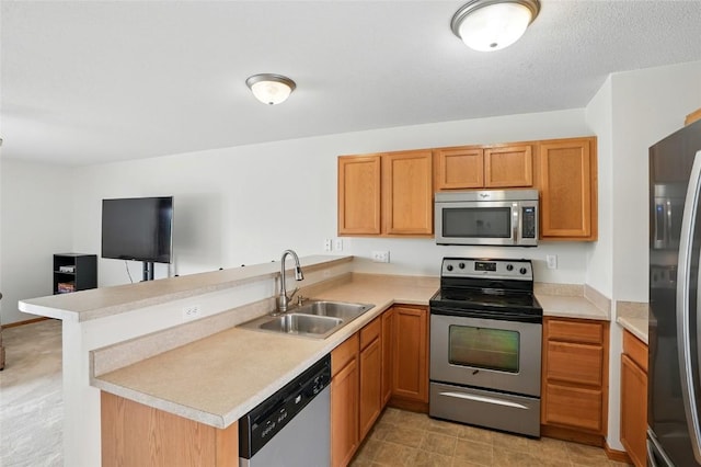 1450 Tower Ln NE, Cedar Rapids, IA 52402 - kitchen with appliances with stainless steel finishes, a sink, a peninsula, light countertops, and open floor plan
