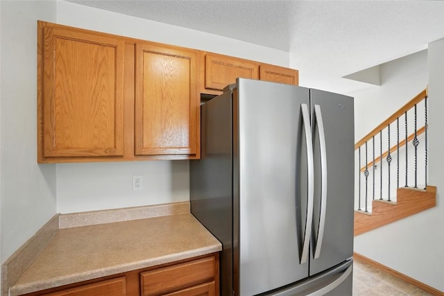 1450 Tower Ln NE, Cedar Rapids, IA 52402 - kitchen with freestanding refrigerator, brown cabinets, and light countertops