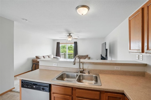 1450 Tower Ln NE, Cedar Rapids, IA 52402 - kitchen with dishwashing machine, a sink, open floor plan, and light countertops