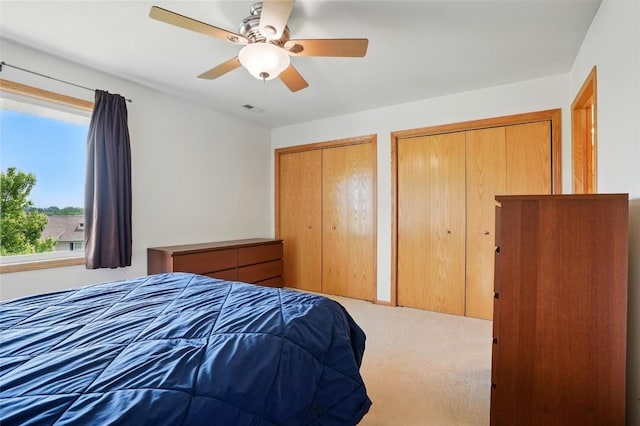 1450 Tower Ln NE, Cedar Rapids, IA 52402 - carpeted bedroom featuring two closets and a ceiling fan