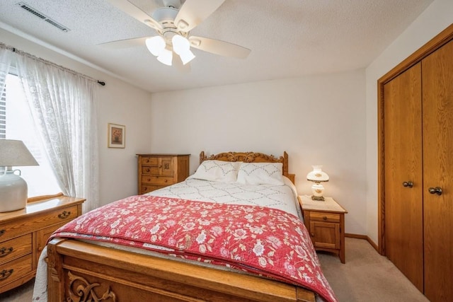 4320 Maureen Ct SE Unit 176, Cedar Rapids, IA 52403 - bedroom with light colored carpet, a closet, a ceiling fan, and a textured ceiling