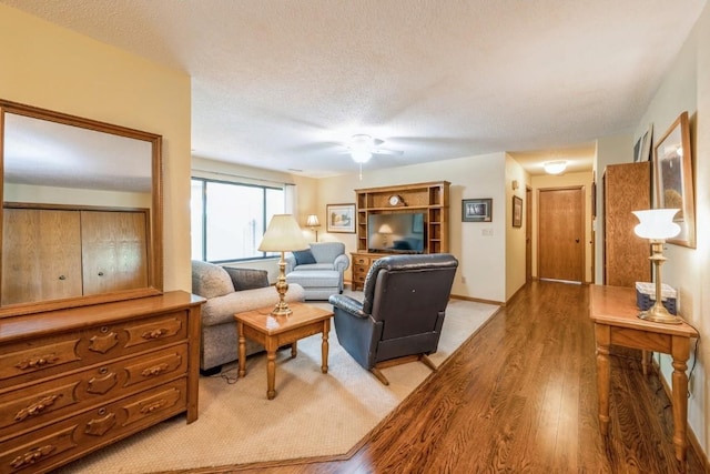 4320 Maureen Ct SE Unit 176, Cedar Rapids, IA 52403 - living room featuring light wood finished floors, a ceiling fan, baseboards, and a textured ceiling