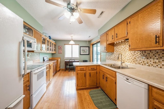 4320 Maureen Ct SE Unit 176, Cedar Rapids, IA 52403 - kitchen featuring white appliances, a sink, light countertops, backsplash, and a peninsula