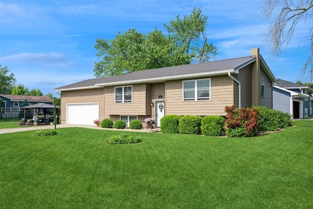 303 6th Ave, Newhall, IA 52315 - raised ranch with a chimney, driveway, a front lawn, an attached garage, and metal roof