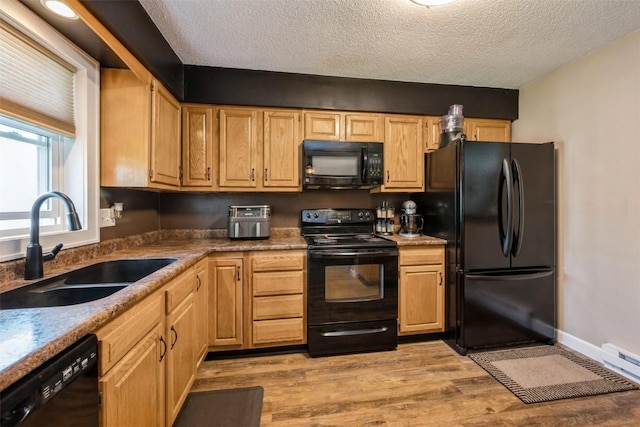 303 6th Ave, Newhall, IA 52315 - kitchen with black appliances, a sink, a textured ceiling, light wood-type flooring, and light brown cabinets