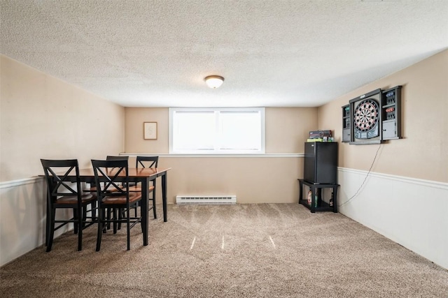 303 6th Ave, Newhall, IA 52315 - dining space featuring a baseboard heating unit, carpet, a textured ceiling, and wainscoting