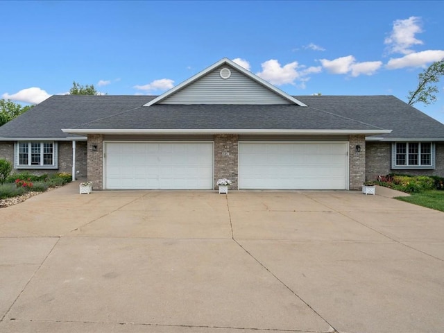 501 Washington Ct SW Unit B, Mount Vernon, IA 52314 - view of front of home with concrete driveway, a garage, brick siding, and roof with shingles