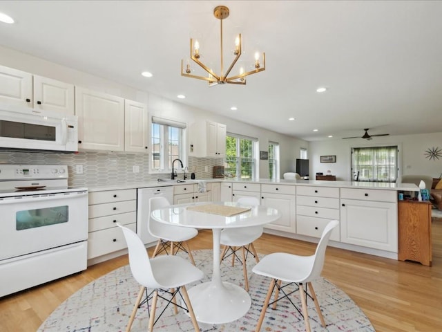 501 Washington Ct SW Unit B, Mount Vernon, IA 52314 - kitchen with white appliances, a peninsula, a sink, decorative backsplash, and a chandelier