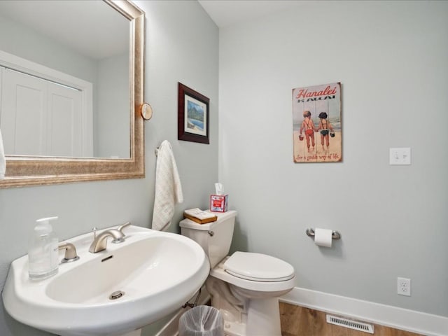 501 Washington Ct SW Unit B, Mount Vernon, IA 52314 - half bath with a sink, wood finished floors, toilet, and baseboards