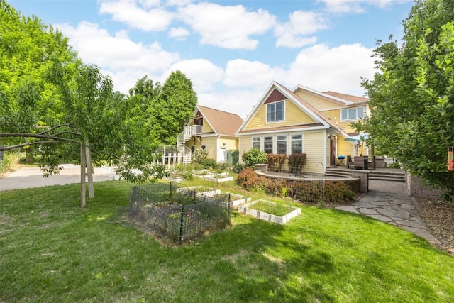 508 W 5th St, Vinton, IA 52349 - rear view of property featuring a vegetable garden and a lawn