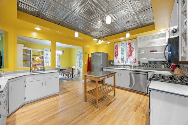 508 W 5th St, Vinton, IA 52349 - kitchen with appliances with stainless steel finishes, an ornate ceiling, a chandelier, light wood-style floors, and white cabinets