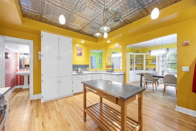 508 W 5th St, Vinton, IA 52349 - kitchen featuring an ornate ceiling, light countertops, light wood-type flooring, and white cabinetry