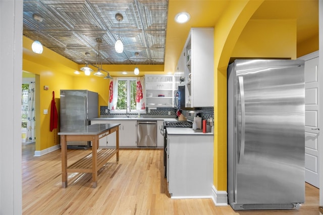 508 W 5th St, Vinton, IA 52349 - kitchen with appliances with stainless steel finishes, an ornate ceiling, white cabinetry, open shelves, and light wood-style floors