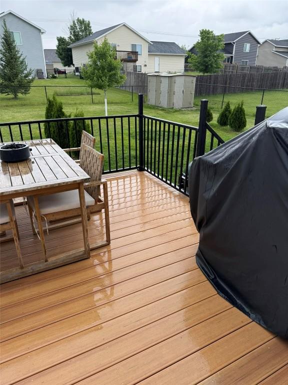 828 73rd NE, Cedar Rapids, IA 52402 - deck with a storage unit, outdoor dining area, and grilling area