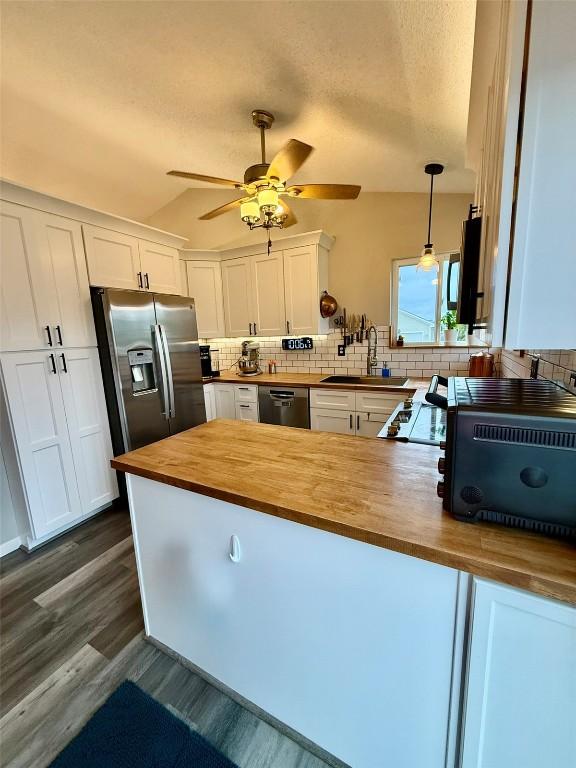 828 73rd NE, Cedar Rapids, IA 52402 - kitchen featuring wooden counters, stainless steel appliances, tasteful backsplash, ceiling fan, and white cabinetry