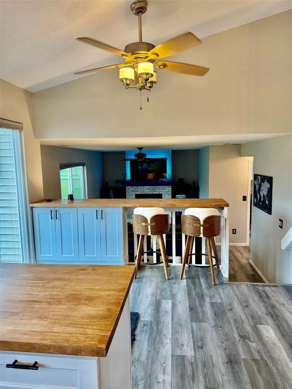 828 73rd NE, Cedar Rapids, IA 52402 - kitchen with vaulted ceiling, wood finished floors, ceiling fan, and butcher block countertops