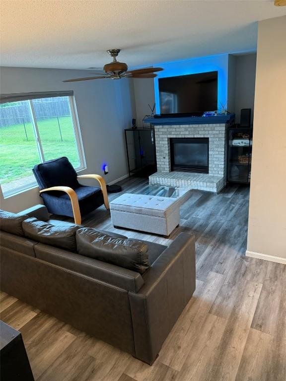 828 73rd NE, Cedar Rapids, IA 52402 - living room with ceiling fan, a fireplace, and wood finished floors