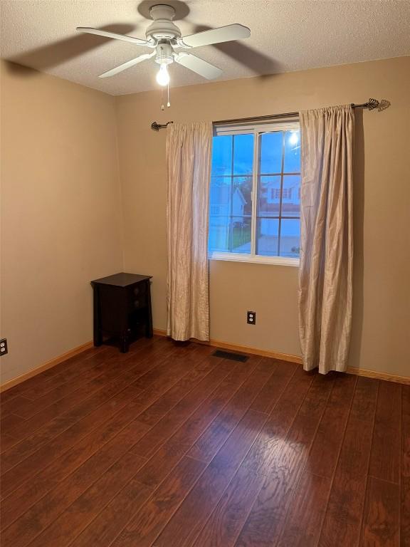 828 73rd NE, Cedar Rapids, IA 52402 - spare room with ceiling fan, dark wood-type flooring, and a textured ceiling