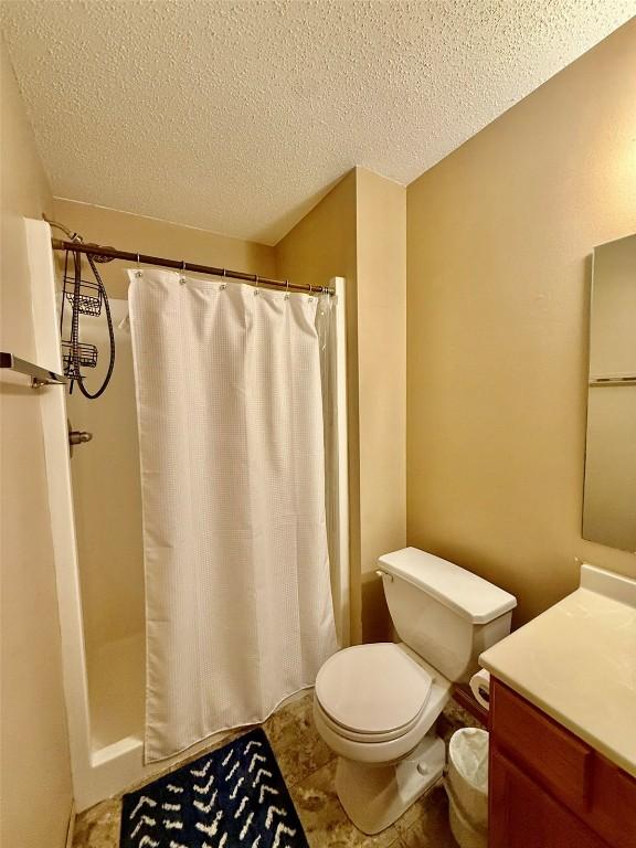 828 73rd NE, Cedar Rapids, IA 52402 - bathroom with vanity, a textured ceiling, and a shower with curtain