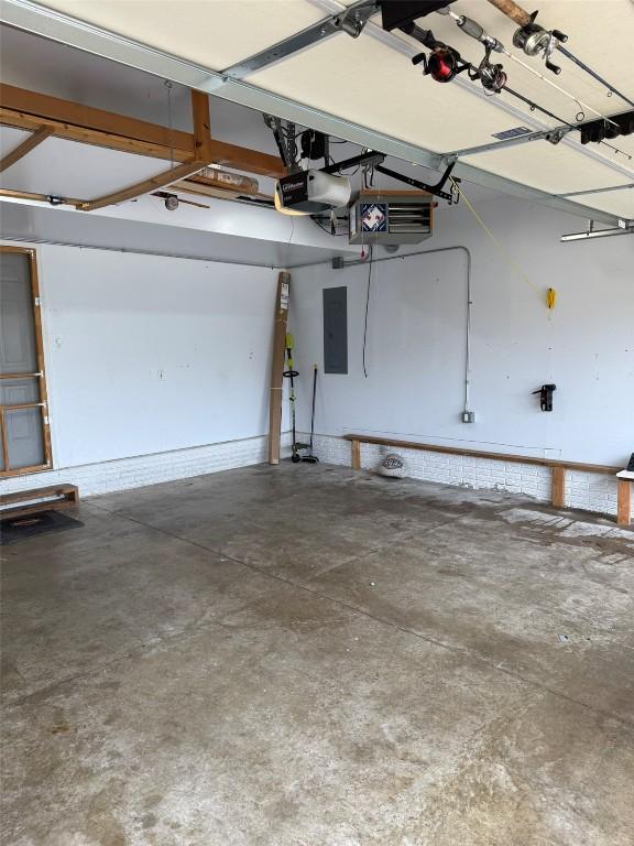 828 73rd NE, Cedar Rapids, IA 52402 - garage featuring a garage door opener, electric panel, and a heating unit
