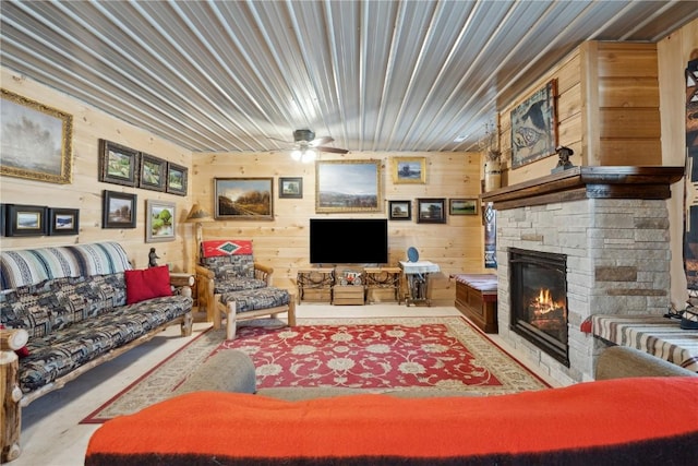 2527 61st St Ln Lot 1, Vinton, IA 52349 - living area featuring a stone fireplace, wooden walls, and a ceiling fan