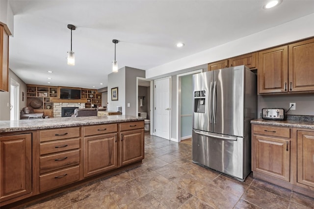 114 Tomahawk Trl SE, Cedar Rapids, IA 52403 - kitchen featuring stainless steel fridge with ice dispenser, a fireplace, hanging light fixtures, recessed lighting, and brown cabinets