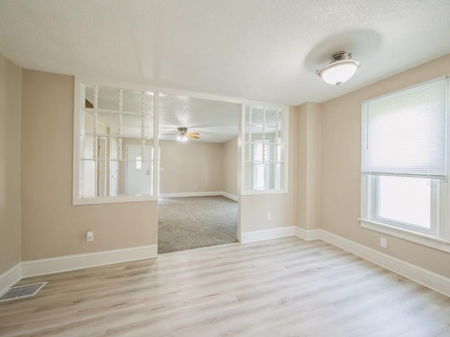 207 Prospect St NW, Blairstown, IA 52209 - spare room with a textured ceiling, plenty of natural light, wood finished floors, and ceiling fan