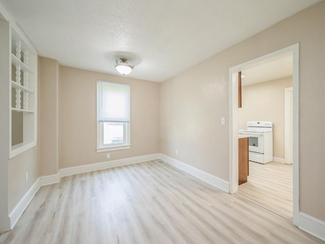 207 Prospect St NW, Blairstown, IA 52209 - spare room featuring light wood-type flooring and a textured ceiling