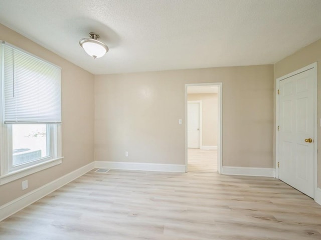 207 Prospect St NW, Blairstown, IA 52209 - unfurnished room featuring light wood-type flooring and a textured ceiling