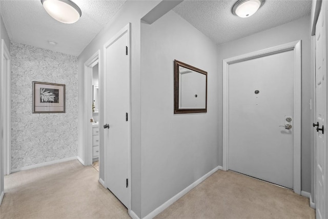 130 Thompson Dr SE Unit 320, Cedar Rapids, IA 52403 - corridor featuring a textured ceiling, light colored carpet, and wallpapered walls