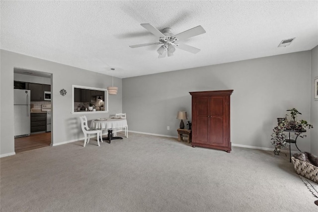 130 Thompson Dr SE Unit 320, Cedar Rapids, IA 52403 - sitting room with light carpet, a ceiling fan, and a textured ceiling