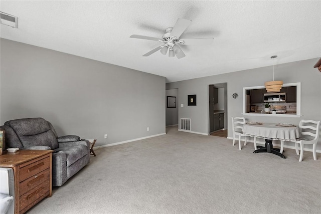 130 Thompson Dr SE Unit 320, Cedar Rapids, IA 52403 - sitting room with a ceiling fan, light carpet, and a textured ceiling
