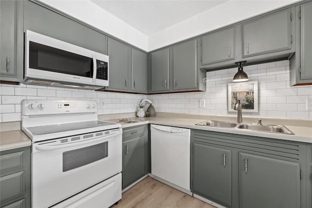 130 Thompson Dr SE Unit 320, Cedar Rapids, IA 52403 - kitchen featuring white appliances, gray cabinetry, light wood-style floors, tasteful backsplash, and light countertops