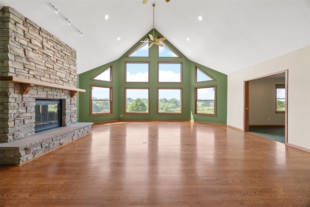 660 Garfield Rd, West Branch, IA 52358 - unfurnished living room featuring wood finished floors, healthy amount of natural light, high vaulted ceiling, and a fireplace