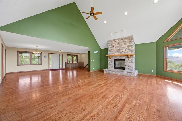 660 Garfield Rd, West Branch, IA 52358 - unfurnished living room featuring plenty of natural light, a stone fireplace, high vaulted ceiling, wood finished floors, and recessed lighting