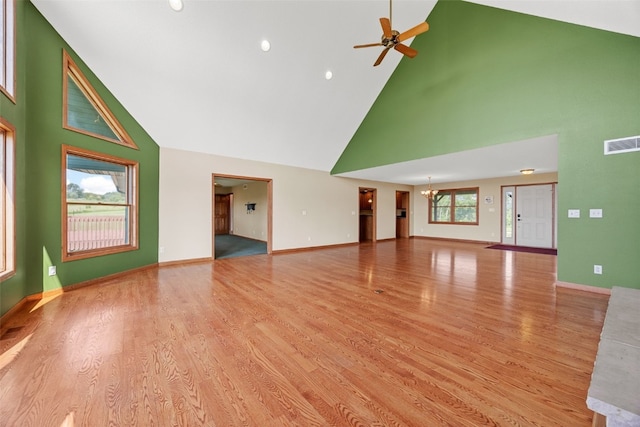 660 Garfield Rd, West Branch, IA 52358 - unfurnished living room with high vaulted ceiling, a ceiling fan, a chandelier, and light wood finished floors