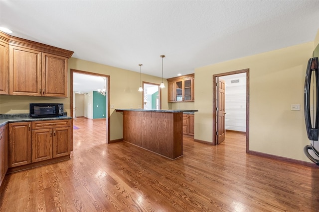 660 Garfield Rd, West Branch, IA 52358 - kitchen with black microwave, dark countertops, brown cabinets, and light wood-style flooring