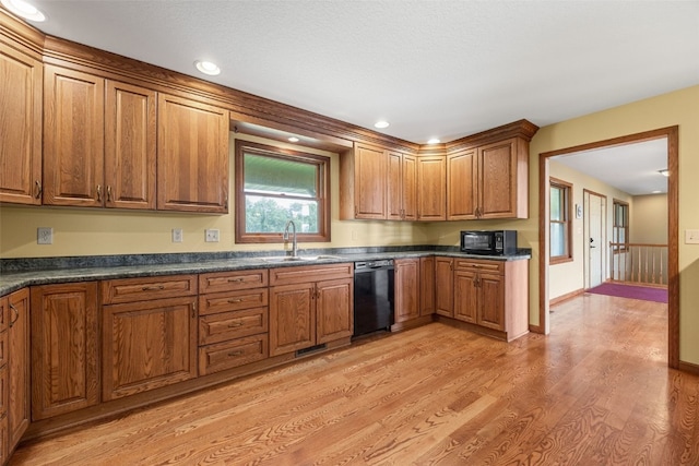 660 Garfield Rd, West Branch, IA 52358 - kitchen featuring black appliances, light wood-style floors, dark countertops, and brown cabinetry