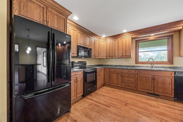 660 Garfield Rd, West Branch, IA 52358 - kitchen featuring black appliances, brown cabinets, light wood-style floors, and recessed lighting