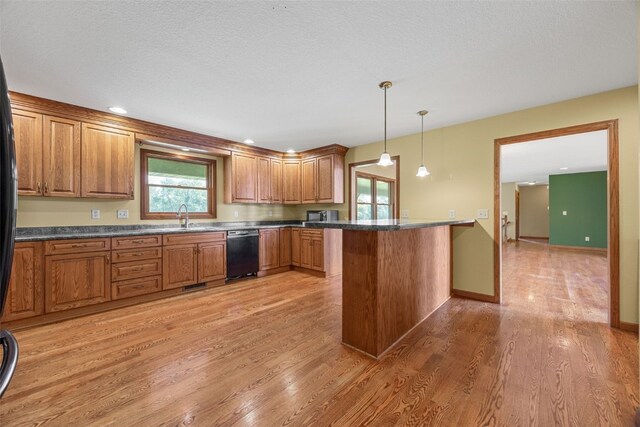 660 Garfield Rd, West Branch, IA 52358 - kitchen featuring black dishwasher, a peninsula, brown cabinetry, and light wood-style flooring