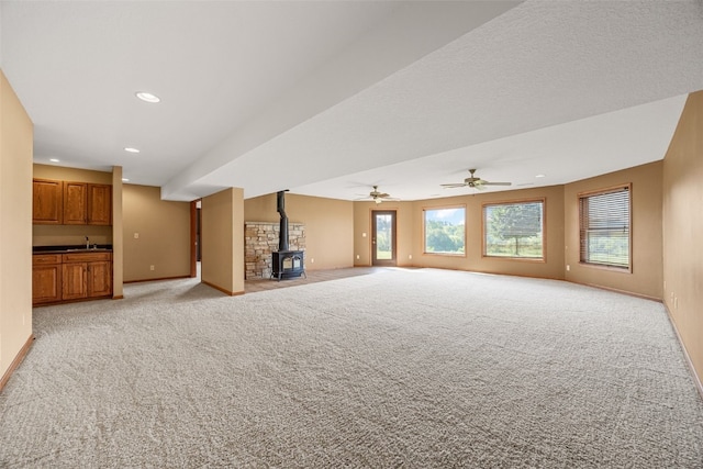 660 Garfield Rd, West Branch, IA 52358 - unfurnished living room featuring a wood stove, light colored carpet, recessed lighting, and ceiling fan