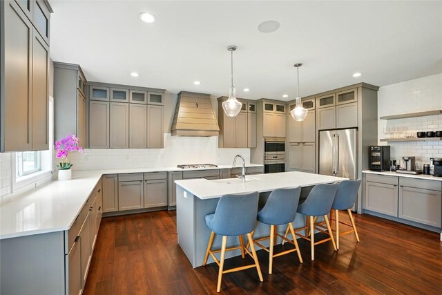 1643 Avalon Pl, Iowa City, IA 52245 - kitchen featuring premium range hood, gray cabinets, tasteful backsplash, a kitchen island with sink, and recessed lighting