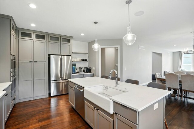1643 Avalon Pl, Iowa City, IA 52245 - kitchen with appliances with stainless steel finishes, gray cabinetry, dark wood-style flooring, a kitchen island with sink, and recessed lighting