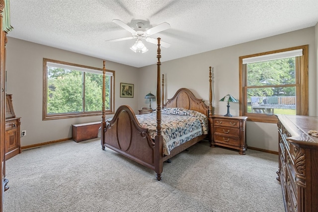 2215 Balsam Ct, Iowa City, IA 52240 - bedroom featuring light colored carpet, multiple windows, a textured ceiling, and ceiling fan