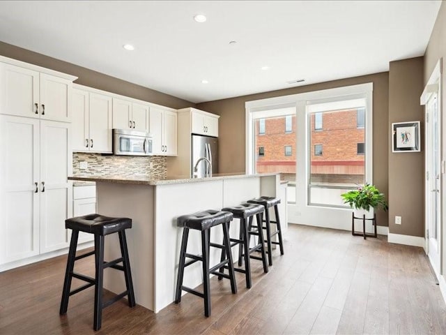 100 4th Ave SW Unit 204, Cedar Rapids, IA 52404 - kitchen with stainless steel appliances, a kitchen breakfast bar, dark wood finished floors, and recessed lighting