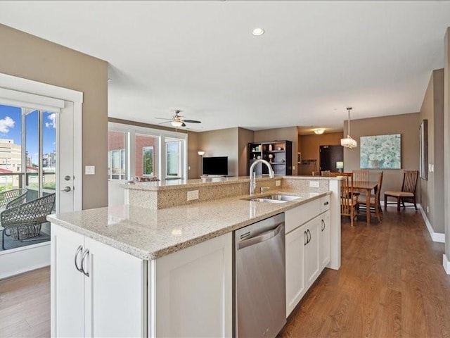 100 4th Ave SW Unit 204, Cedar Rapids, IA 52404 - kitchen featuring dishwasher, white cabinets, wood finished floors, open floor plan, and light stone counters